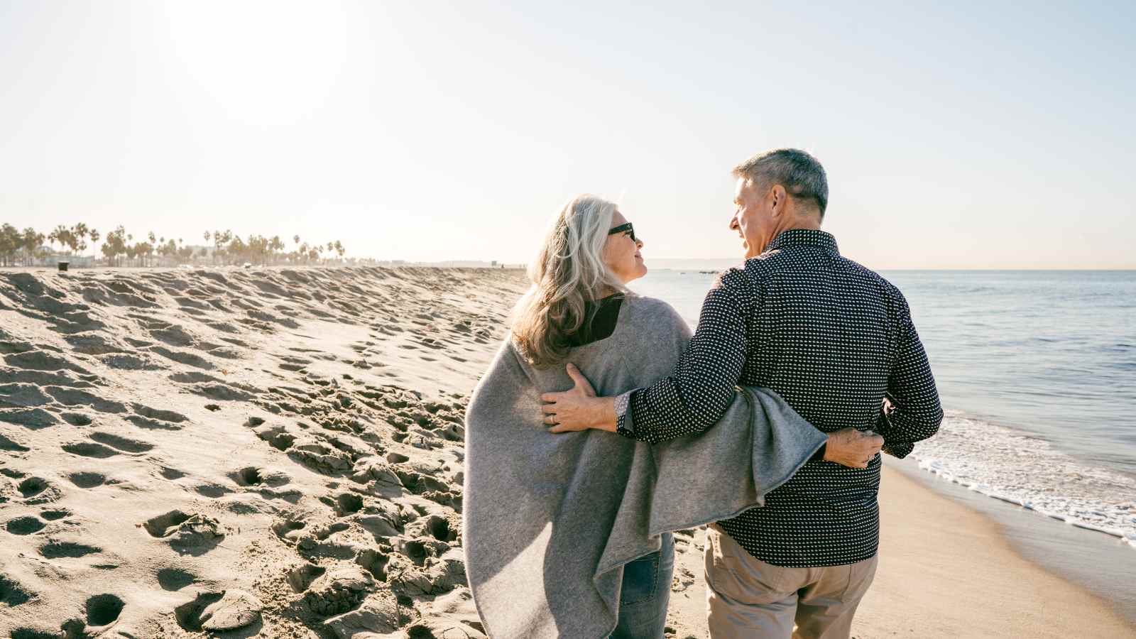 Woman and man on beach looking at each other